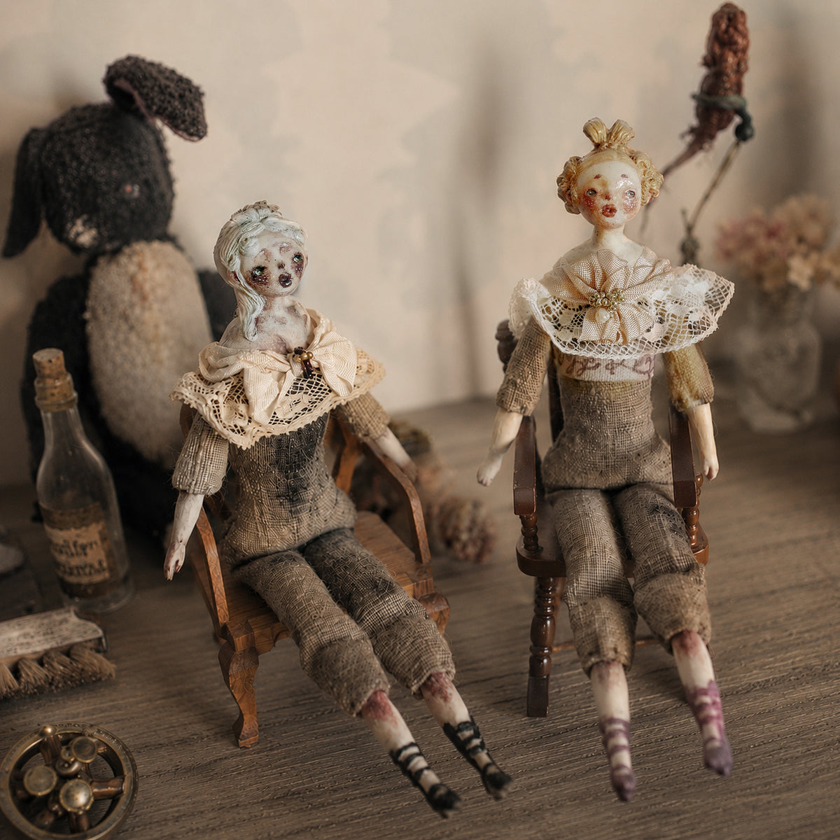 Two seated Lambwick art dolls with different hair colors and striped stockings.