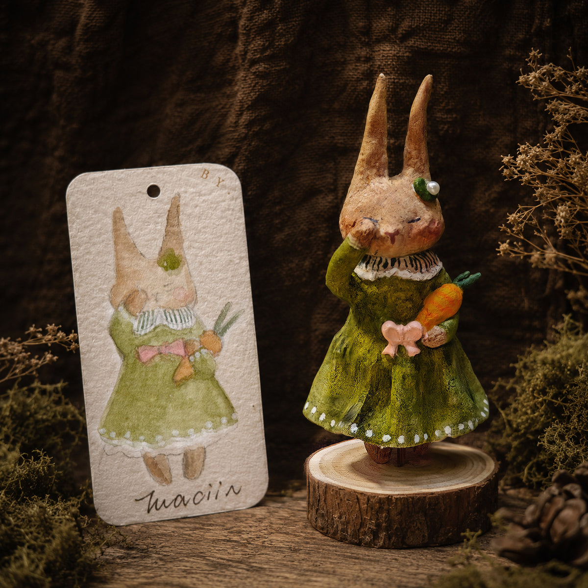 Green-dress Willowwick rabbit doll beside its matching watercolor character card.