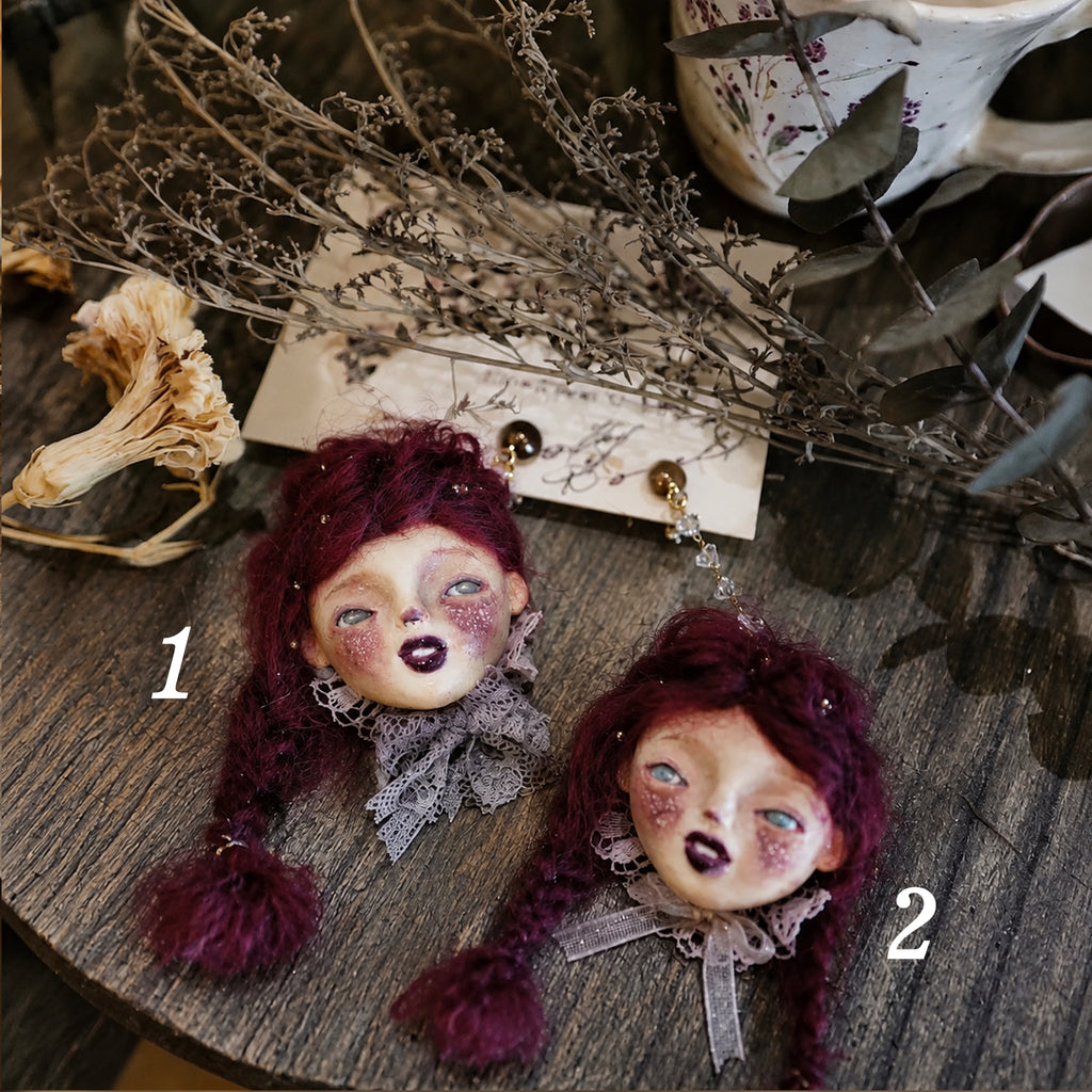 Two purple-haired Lambwick doll earrings with lace collars, labeled 1 and 2.