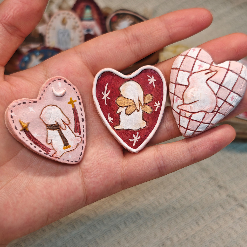 Close view of three heart-shaped Winterwood Storybook brooches.