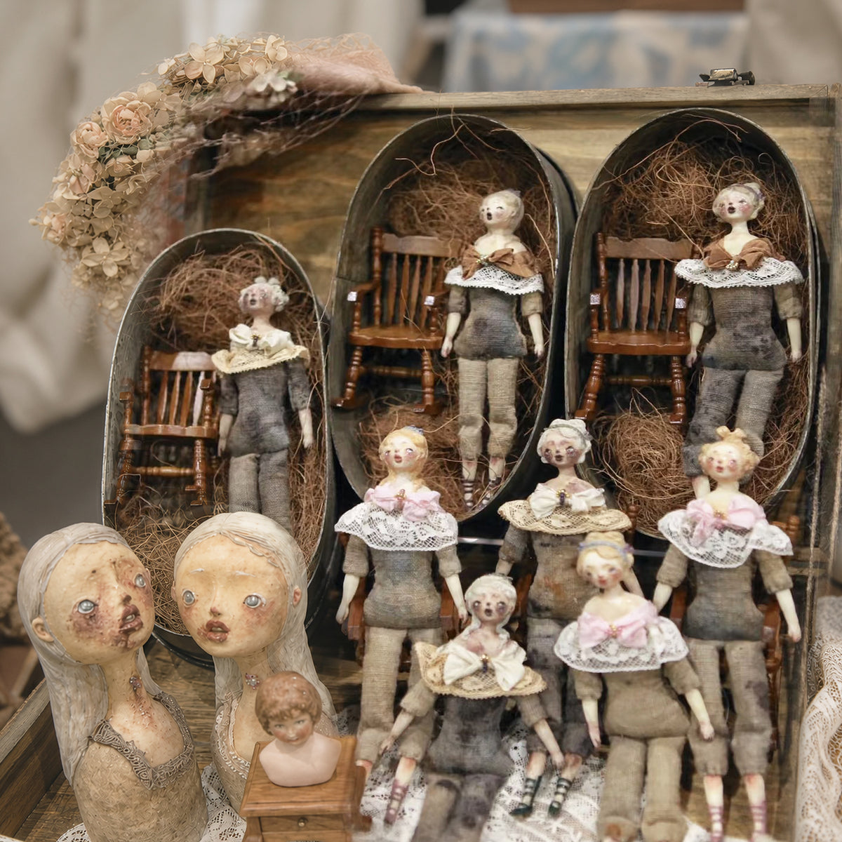 Lambwick art dolls and miniature portrait busts arranged around two display cabinets.