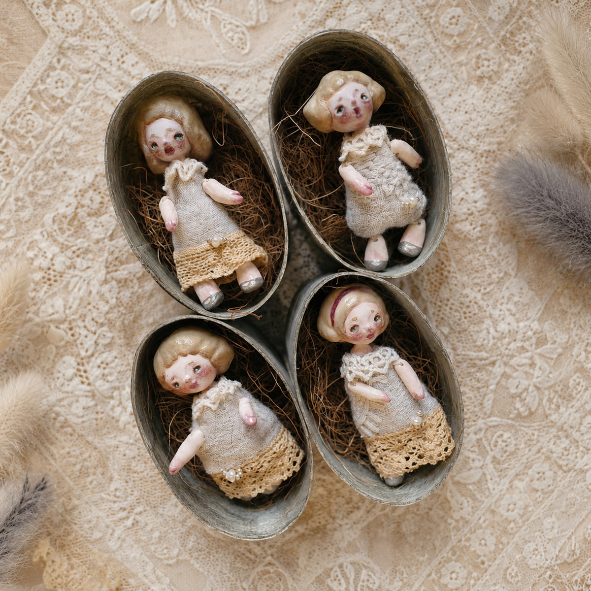 Four miniature Lambwick resident dolls in individual oval presentation boxes.