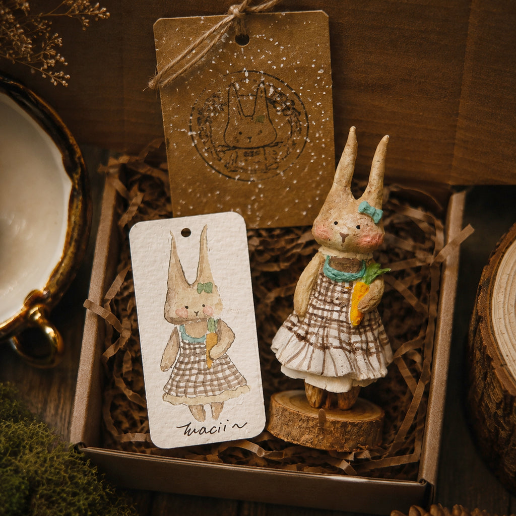 Willowwick rabbit doll in a checked dress and green scarf, displayed with its character card.