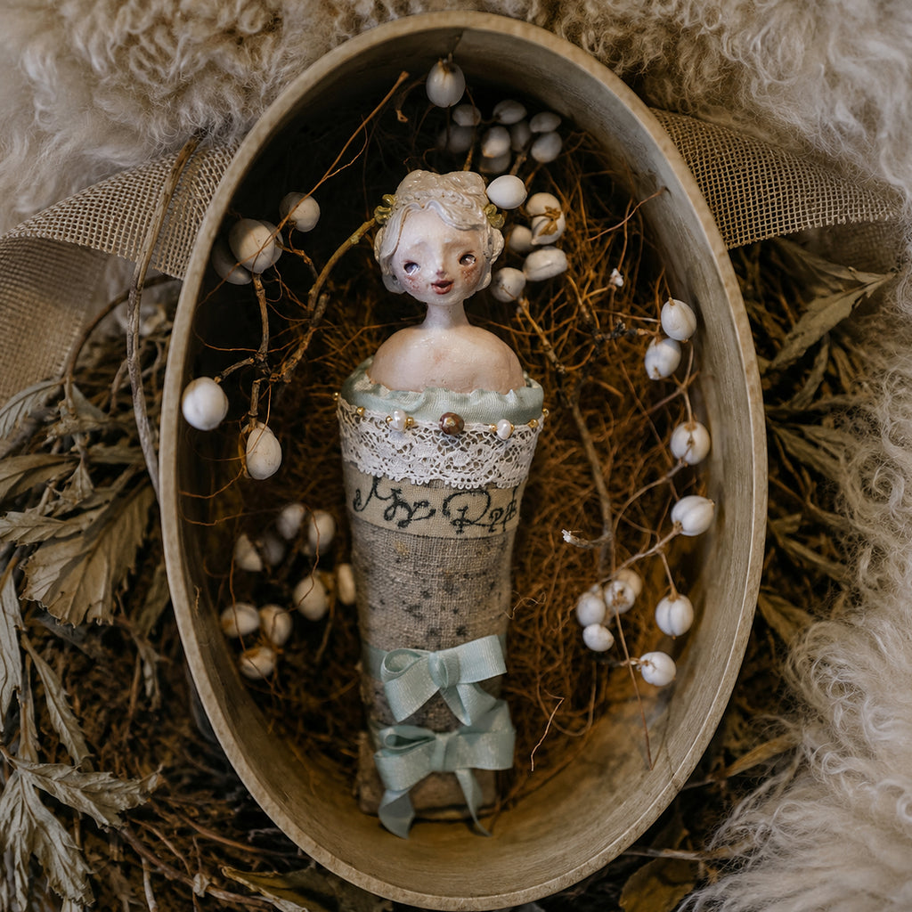 Blue-ribbon Lambwick Twin Series doll brooch inside an oval presentation box.