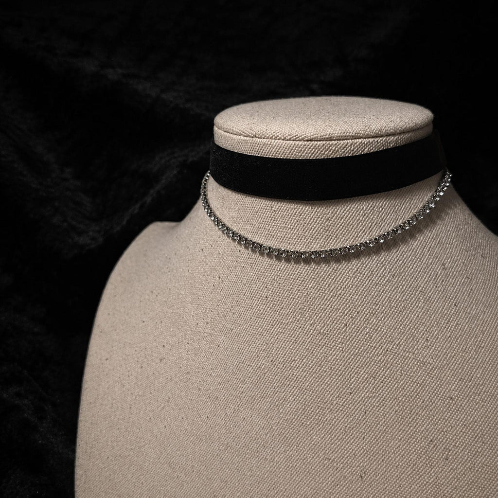 Black velvet ribbon choker and fine silver-tone chain displayed on a jewelry bust.