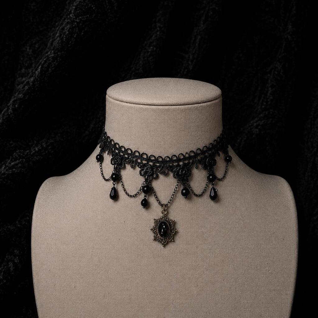 Black gothic choker with beaded loops and a dark teardrop pendant on a jewelry bust.