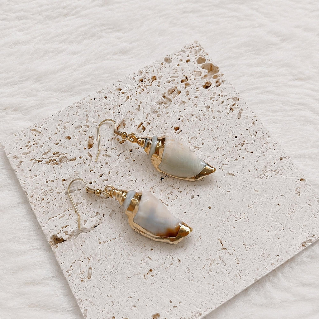 Pair of pointed pale shell earrings with gold-tone caps and tips.