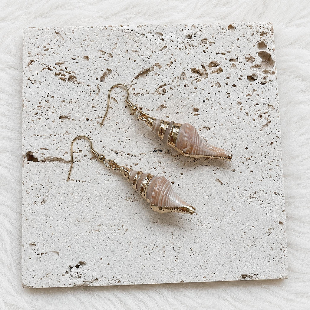 Reverse view of pointed spiked conch-shell earrings showing the shell openings.