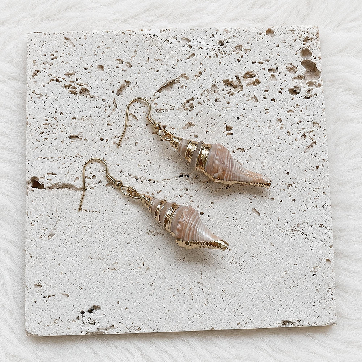 Reverse view of pointed spiked conch-shell earrings showing the shell openings.