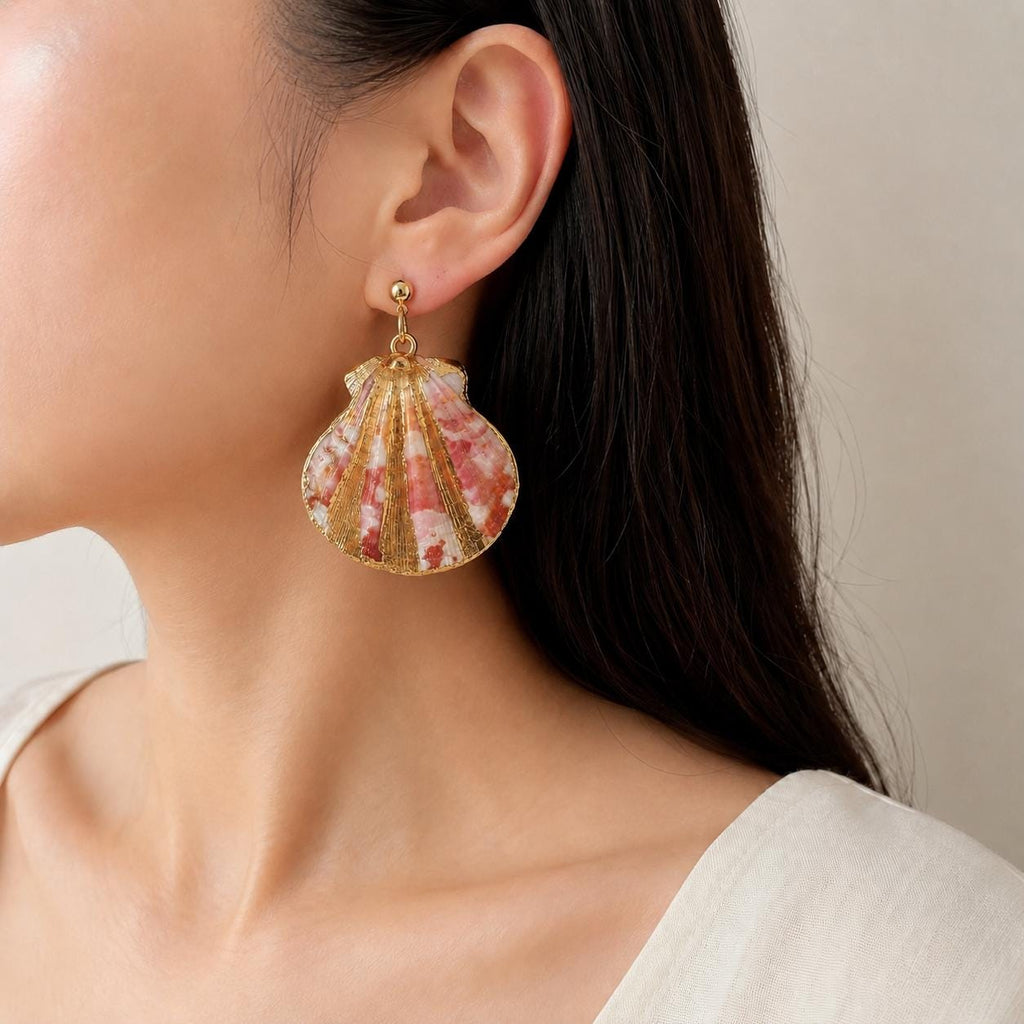 Large red-and-cream fan-shell earring shown worn beside an ivory blouse.