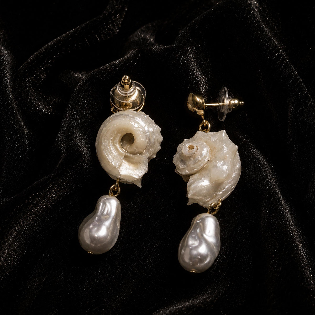 Rear and side view of spiral conch-shell stud earrings with pale bead drops.