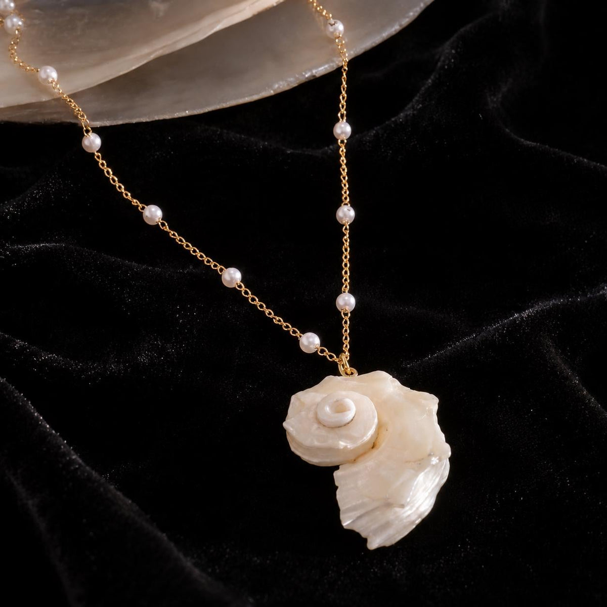 Iridescent conch-shell necklace displayed against a pale shell dish.