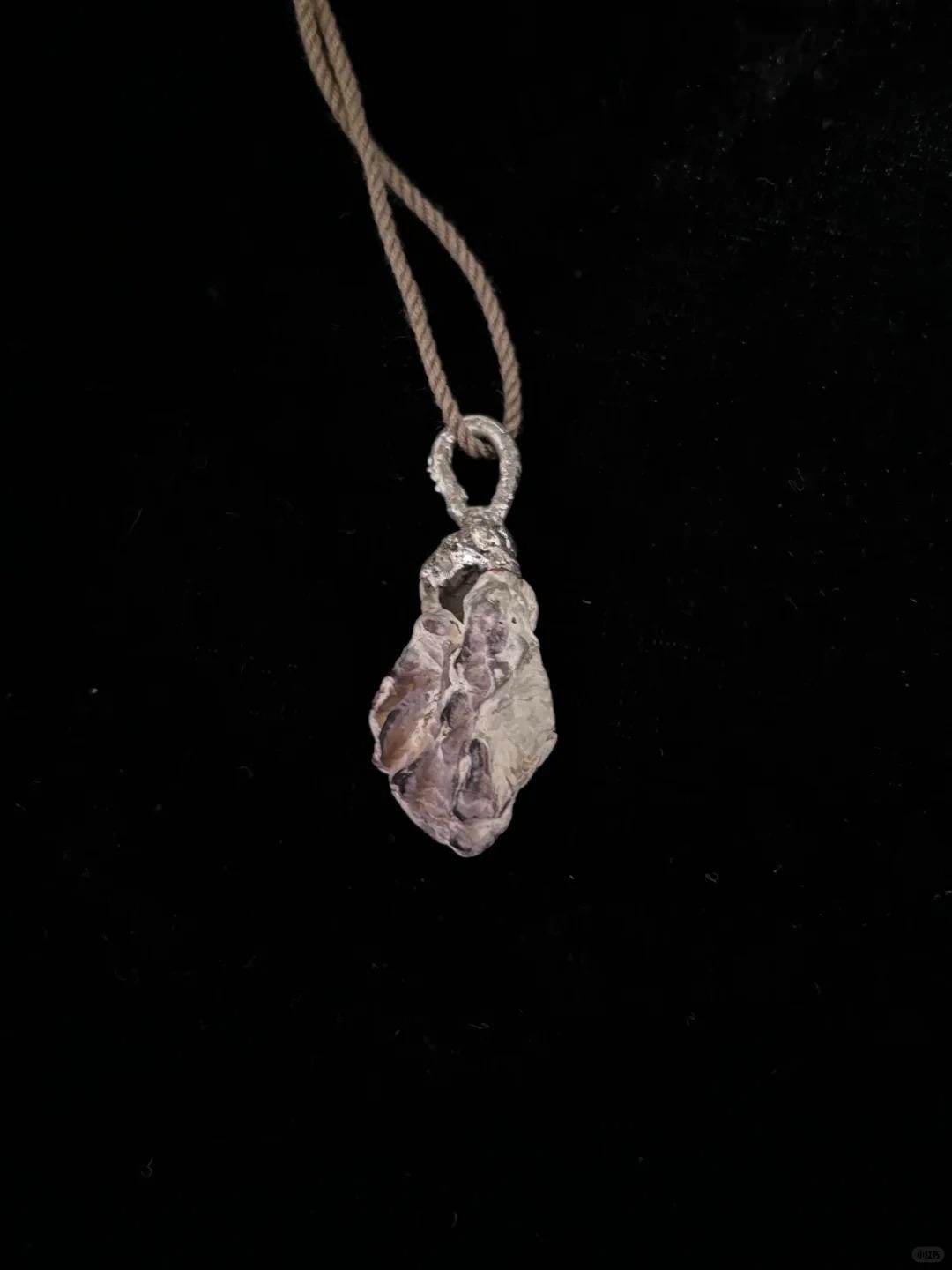 Reverse of the Shell Pearl Talisman pendant showing the natural shell texture and brown cord.