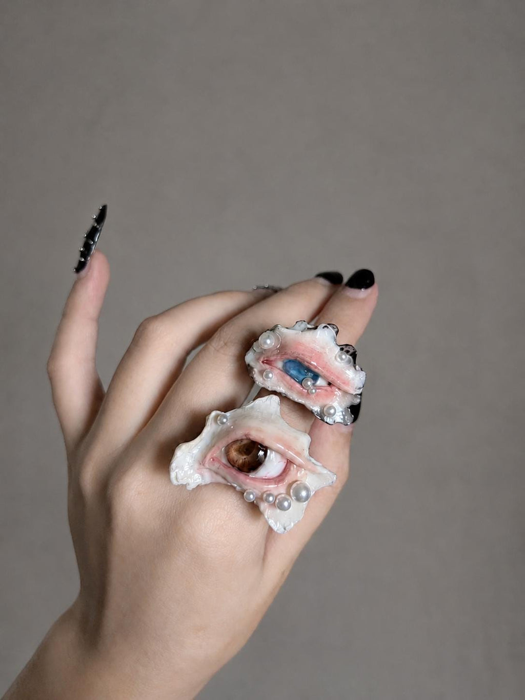 Two shell-eye statement rings worn on adjacent fingers, viewed from the front.