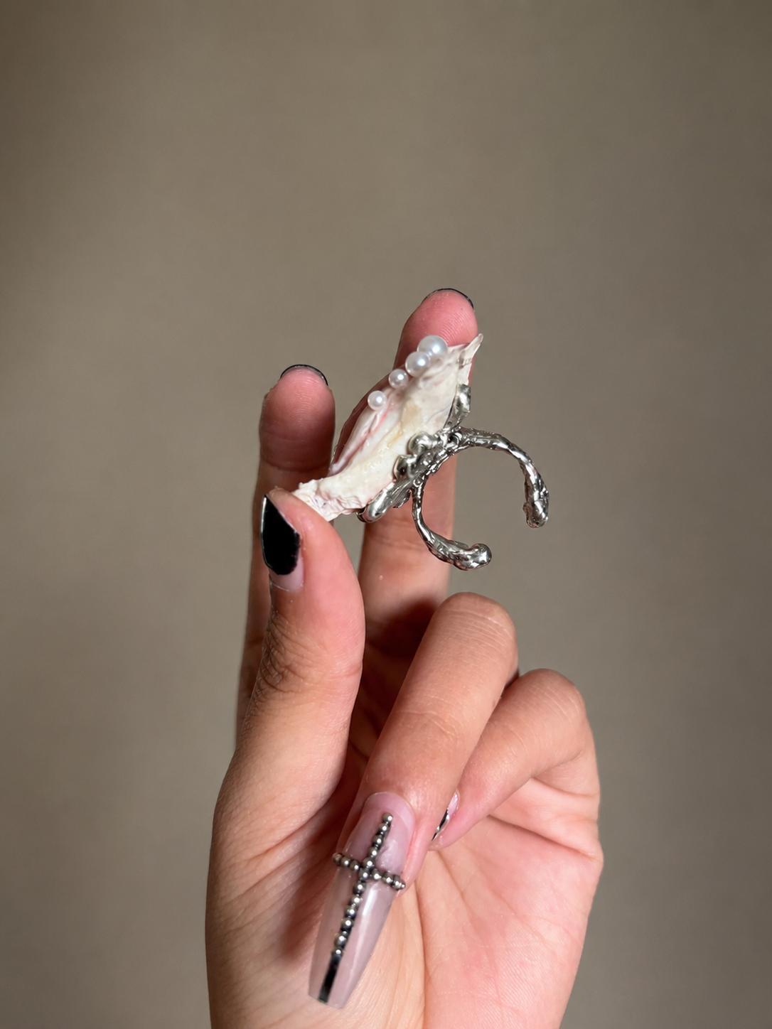 Side and underside of a shell-eye statement ring showing its adjustable metal band.