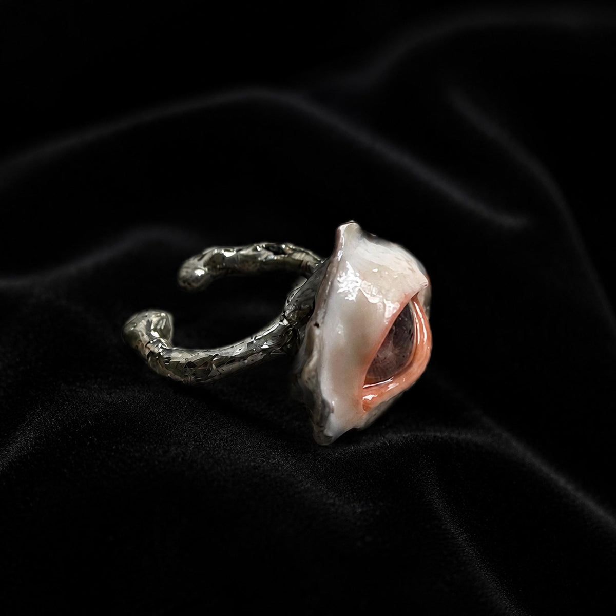 Side view of a brown-pupil oyster-eye ring showing the shell depth and adjustable metal band.