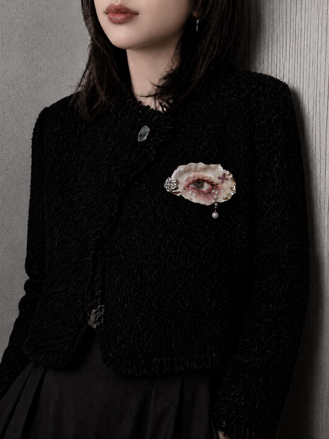 Gilded Oyster Eye brooch pinned to a black knitted top.