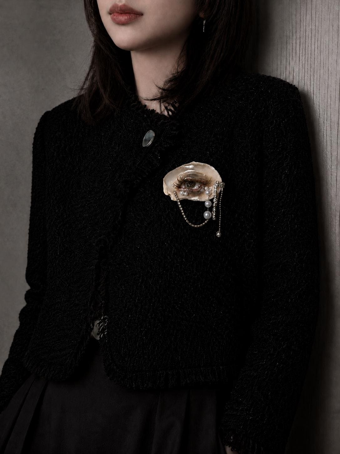 Brown Smoky Oyster Eye brooch worn on a black knitted top.