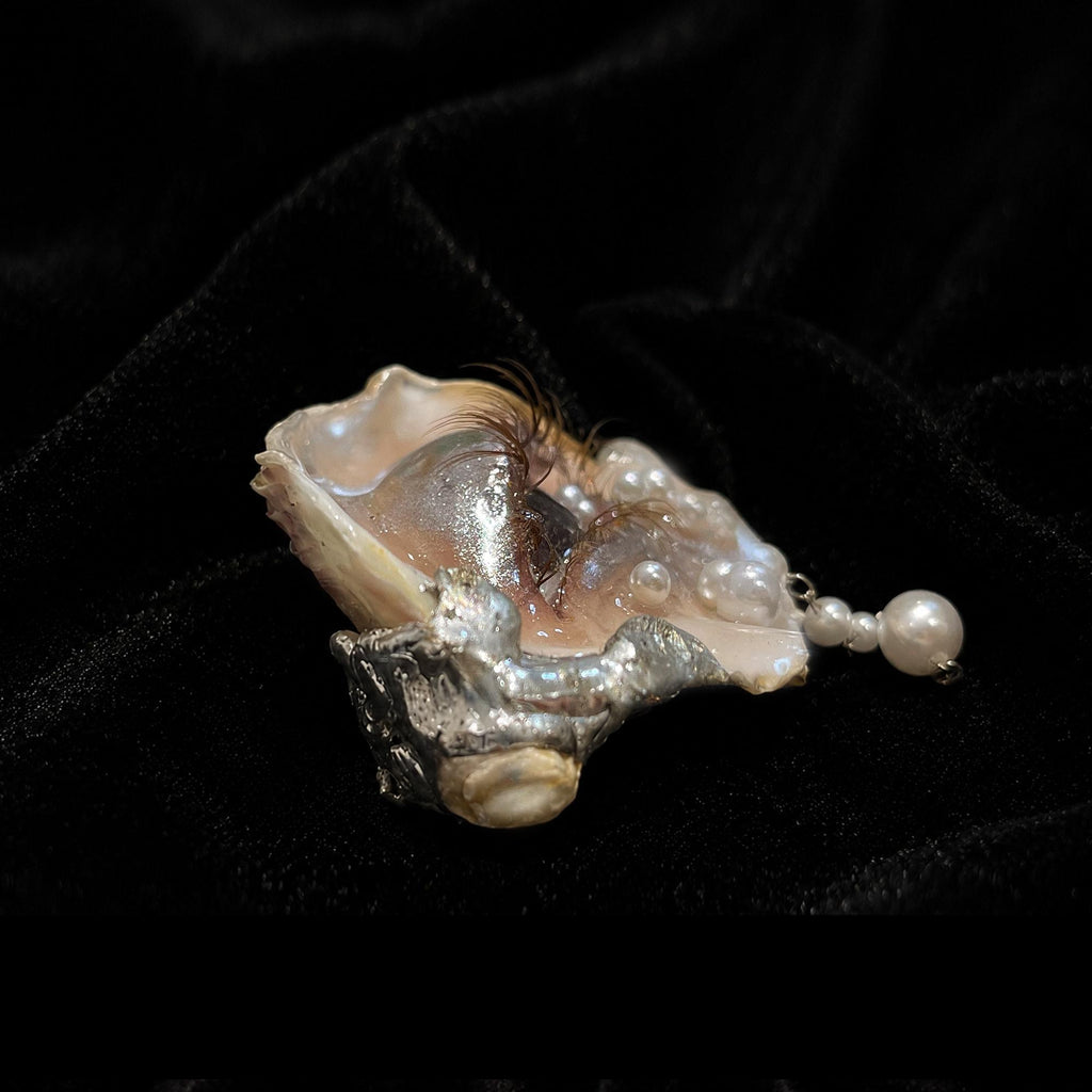 Side view of Brown Smoky Oyster Eye showing the shell depth and raised sculpted eyelid.