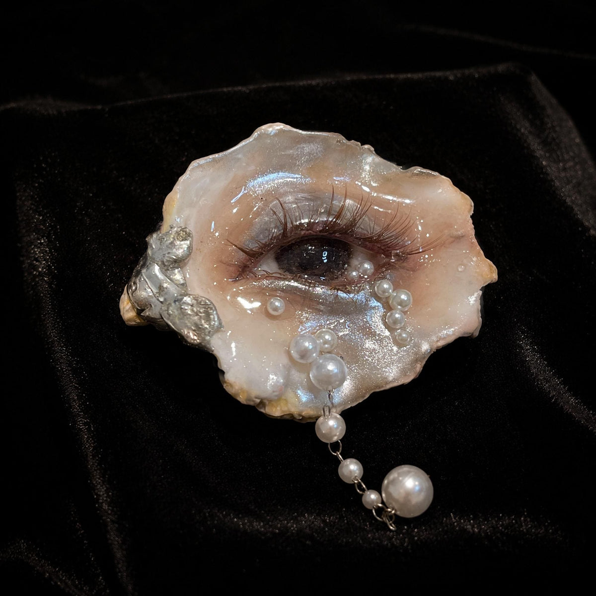 Brown Smoky Oyster Eye brooch with pale bead accents resting on black velvet.