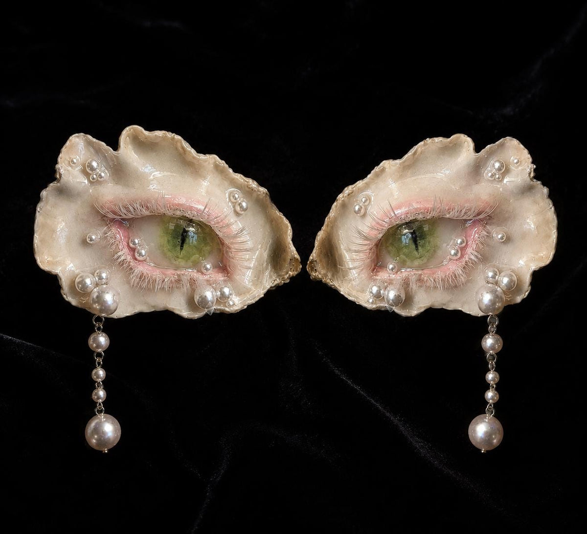 Two Cat-Eye Green Pupil pieces in different sizes arranged on black velvet.