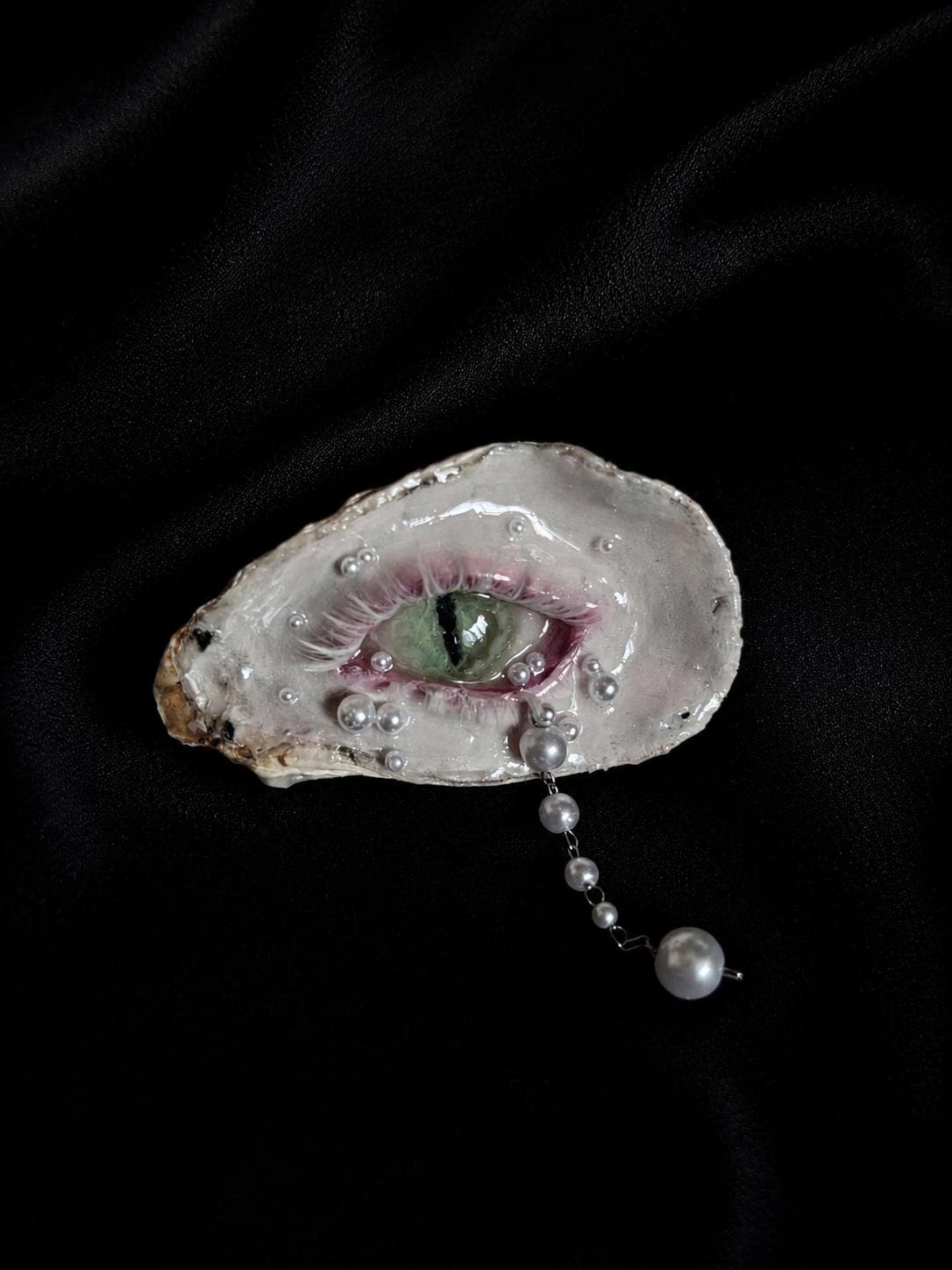 Cat-Eye Green Pupil shell-eye piece with a green iris and vertical pupil on black velvet.