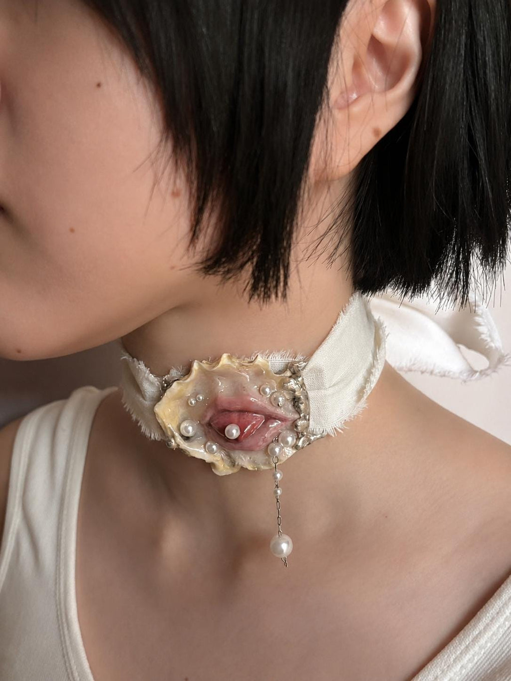 Shell Mouth Relic worn as an ivory-ribbon choker.