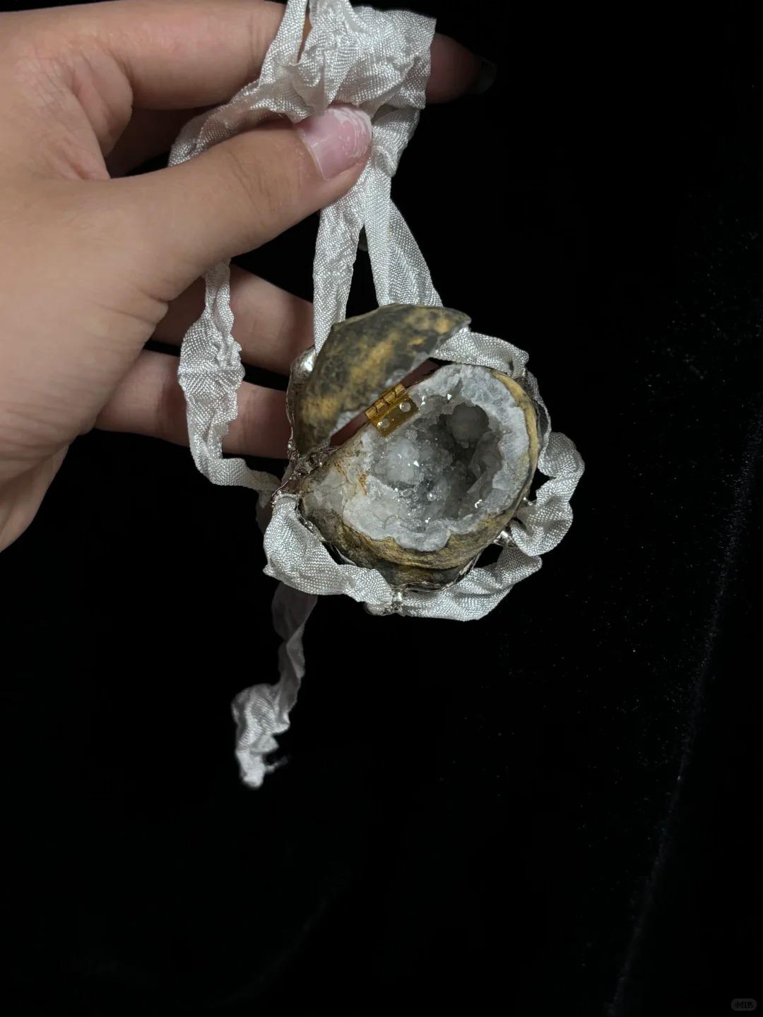 Open Geode Shell Trinket Box hanging from pale ribbon held in a hand.