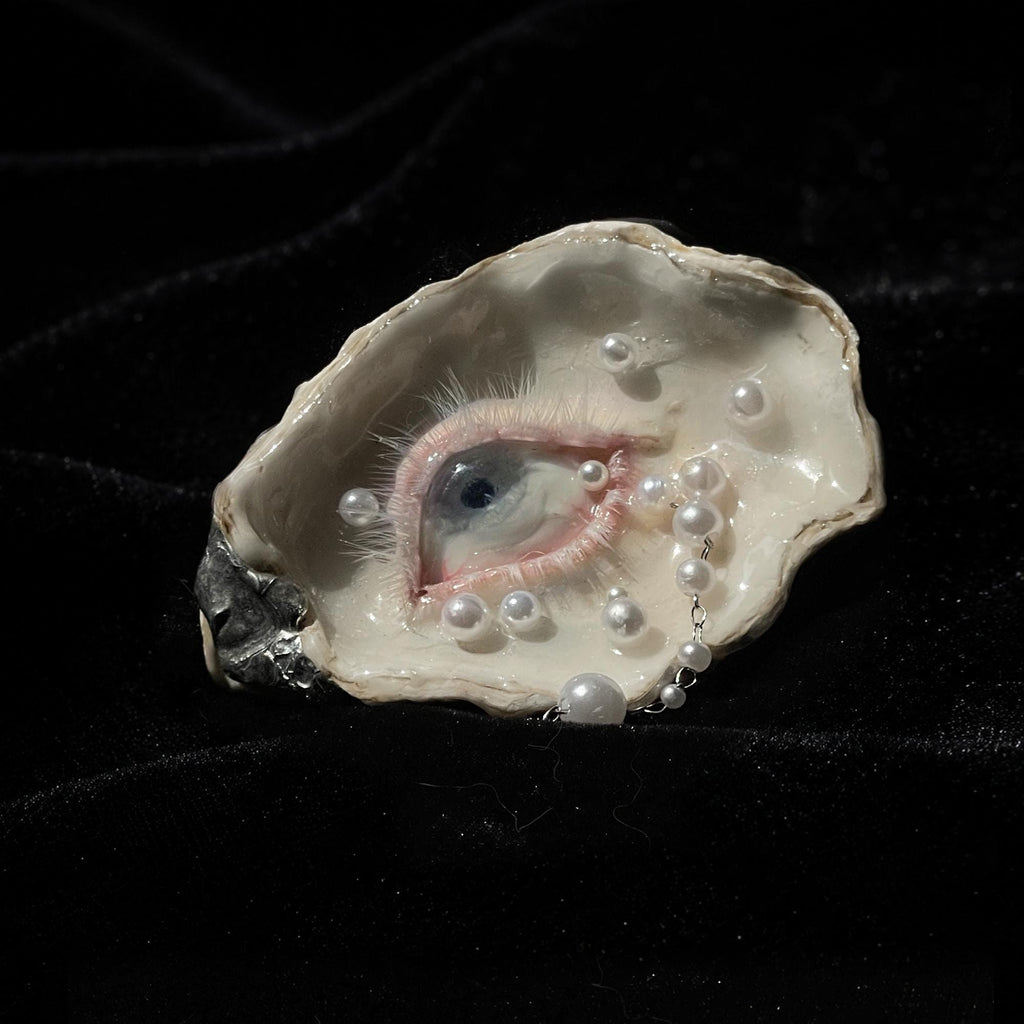 Close-up of Nyra Unimpressed Gaze showing its pale iris and narrow pink eyelid.