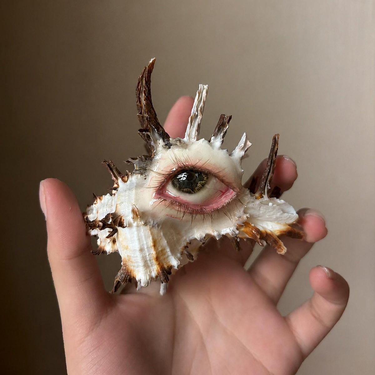 Angled hand-held view of the Abyss Guardians shell-eye artwork and its long spikes.