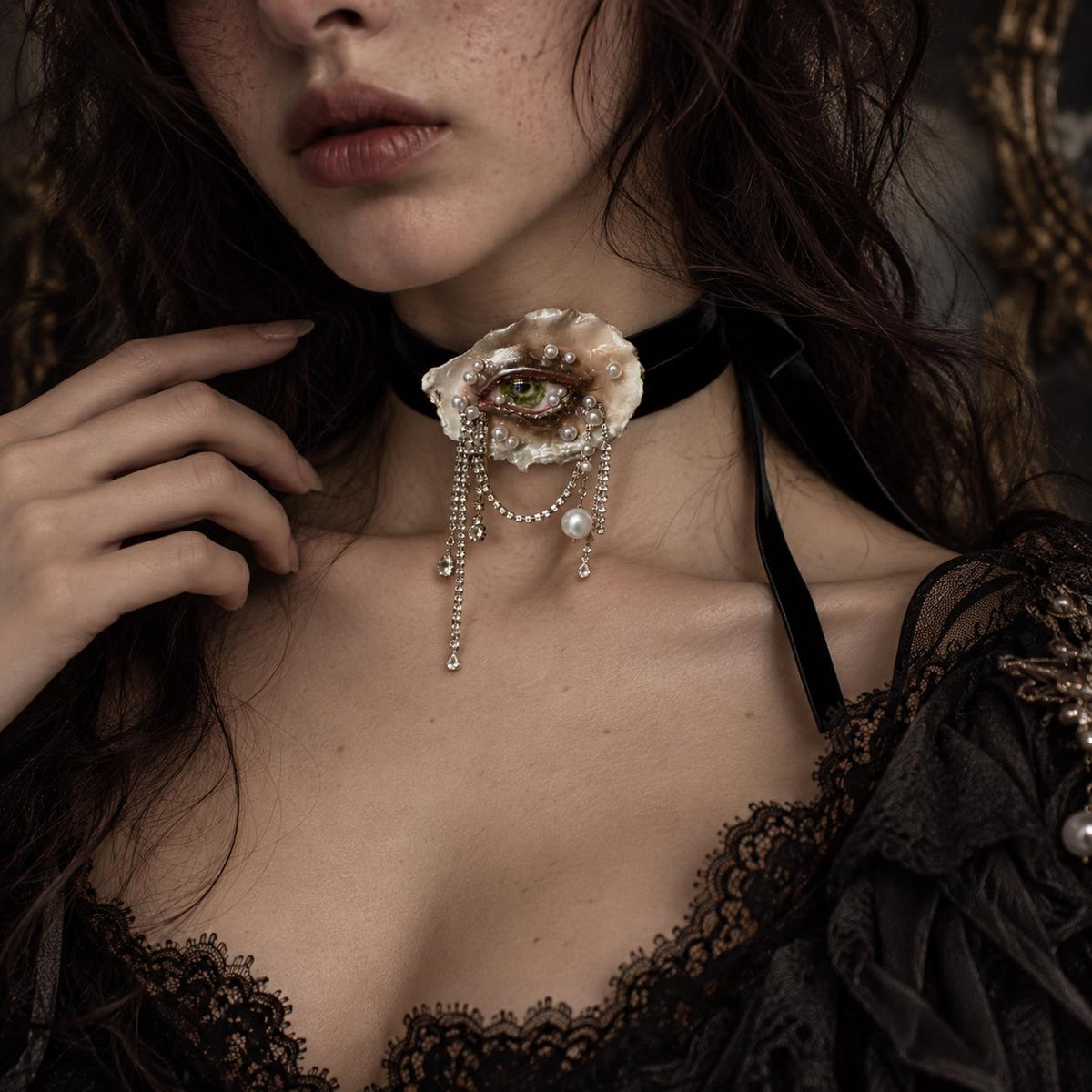 Lilith Veil Emerald Siren oyster eye worn as a black velvet choker with long draped chains.